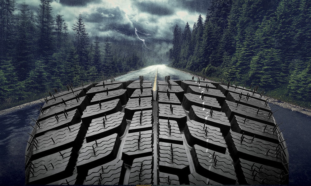 A tire traversing on a road during a rain storm